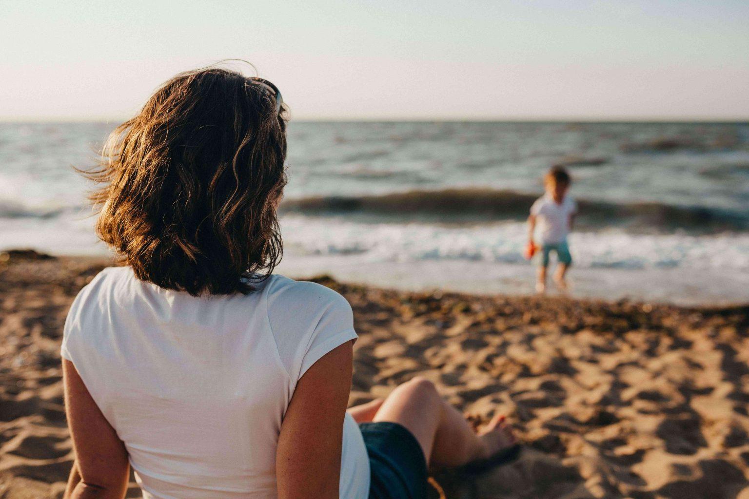 pregnant-mom-watching-her-child-at-beach