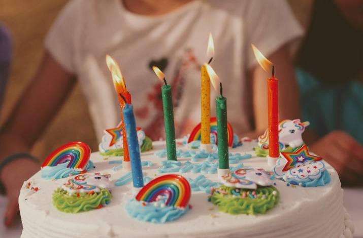 a child holding a birthday cake with candles