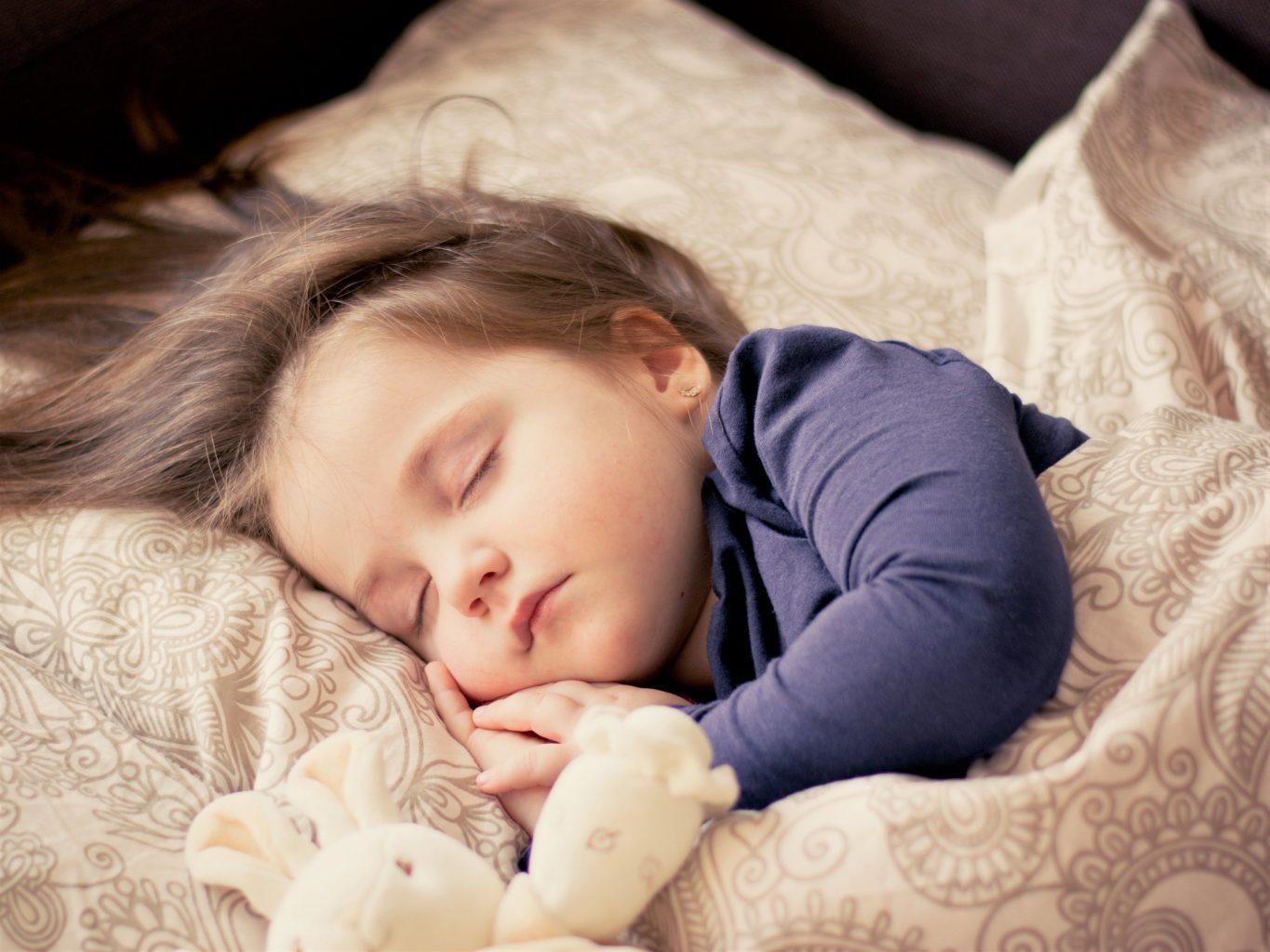 baby sleeping on the bed wrap in weighted blanket