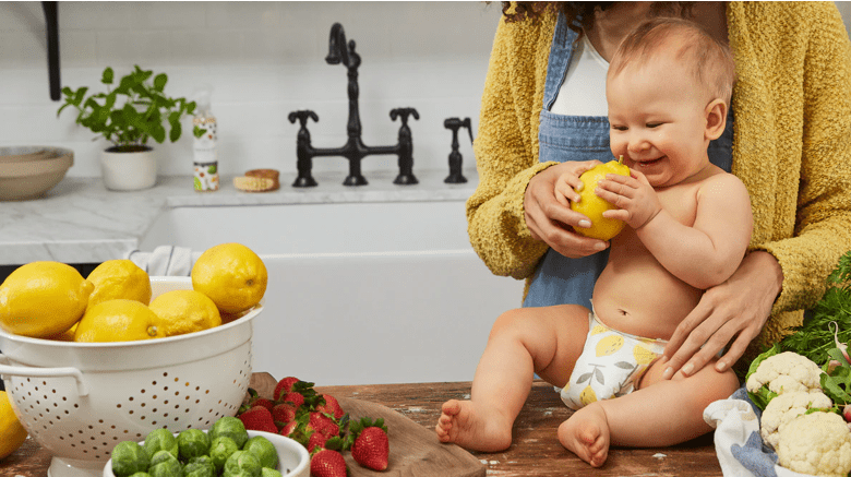 baby on a table delighted with a lemon